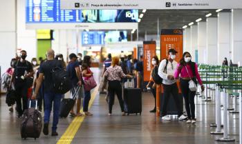 várias pessoas andando no sagão de um aeroporto