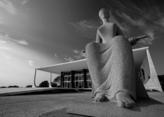 Edificação cinza e preta com escultura simbolizando uma mulher que está com olhos vendados