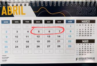 Calendário nas cores azul, amarelo e branco. Há um círculo na cor vermelha em volta dos números 5,6 e7