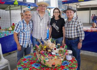 Na foto, quatro pessoas em pé. Na mesa, um balaio com produtos agrícolas.