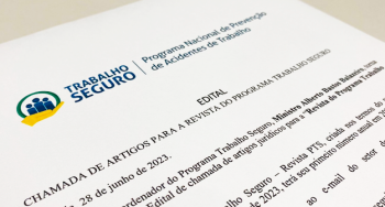 Folha branca com letras nas cores preta e azul. Há um desenho representando pessoas envolta de um círculo verde e amarelo. O documento é o Edital de chamada para publicação de artigos jurídicos. 