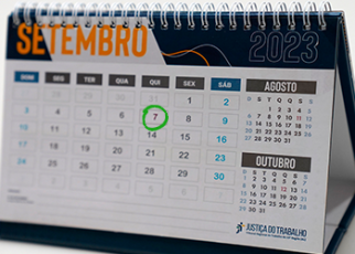 Calendário marcando o mês de setembro. Nas cores azul, branco e amarelo. Há um círculo verde em volta do número sete.