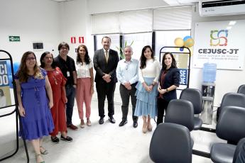 Na foto, todos em pé, cinco mulheres e três homens. Ao lado direito, a logomarca do Cejusc