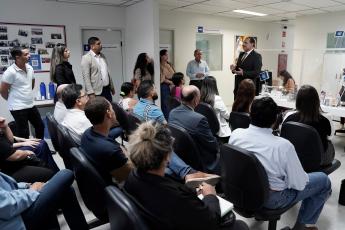 Foto mostra pessoas sentadas na sala de espera do Cejusc, tendo à frente o juiz Flávio Costa