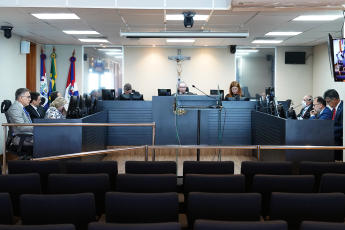 Foto do pleno no Tribunal com o presidente do órgão sentado ao centro da bancada; ao lado esquerdo três desembargadores sentados e, ao lado direito, dois desembargadores sentados