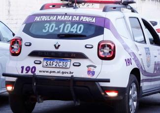 Há uma viatura policial branca da Patrulha Maria da Penha