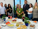 Vária pessoas reunidas em frente a uma mesa com guloseirmas