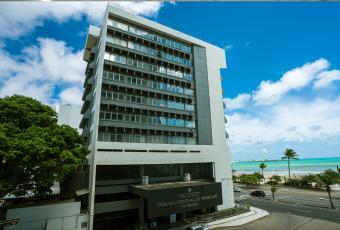 Edifício-sede do TRT-19 nas cores cinza e preto com fachada de vidro.