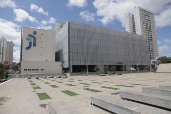 Fachada  do edifício-sede do TRT-18 (GO) na cor cinza claro. Há ainda na fachada a logomarca da Justiça do Trabalho nos tons de azul escuro e amarelo.
