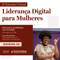  Mulher Negra, com cabelo curto, mas volumoso. Está sorrindo e apontando o indicador da mão esquerda pra cima. Ela usa brincos circulares grandes e uma camisa com detalhes de ilustração de mulheres negras. 