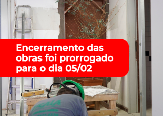 Há um local em obras de reforma. No centro da imagem tem uma tarja vermelha com letras brancas.