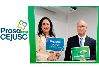A imagem mostra duas pessoas posando sorridentes em uma moldura verde com cartazes nas mãos, durante o evento “Prosa com CEJUSC”. À esquerda, uma mulher segura o cartaz com a frase “Prosear para conciliar”, e à direita, um homem com traje formal segura outro com a frase “Com prosa a gente se entende”. Ao fundo, o ambiente interno reforça o clima institucional do evento promovido pelo CEJUSC do TRT da 19ª Região.