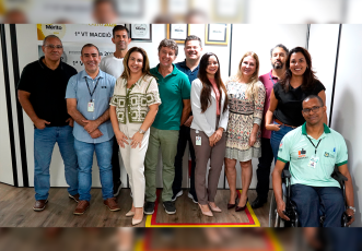 Grupo de várias pessoas posando para foto; uma delas é cadeirante