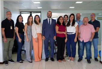 Onze pessoas em pé, sendo cinco homens e seis mulheres, todos estão de frente e em pose para a foto.