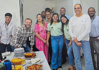 Grupo de homens e mulheres em uma confraternização com bolo e café