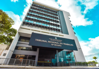 prédio cinza com placa preta e letras douradas com o nome Tribunal Regional do Trabalho da 19ªRegião