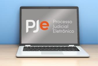 FOTO DE UM NOTEBOOK PJE PROCESSO JUDICIAL ELETRÔNICO ESCRITO AO CENTRO.