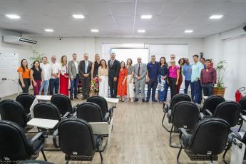 Grupo de pessoas posando para foto em um auditótio.