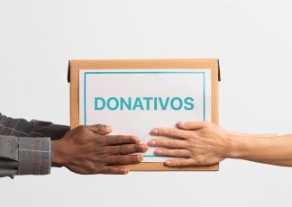 Um mão entregando uma caixa com a palavra donativos para outra mão 