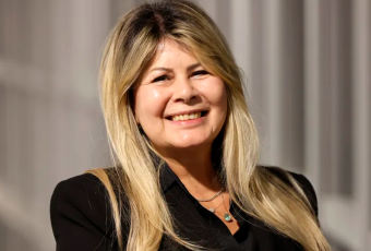 Mulher loira sorrindo de roupa preta