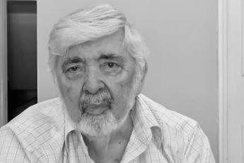 Homem de pele idoso de pele clara. Ele tem cabelo e barba brancos.