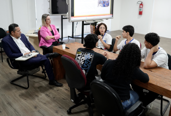 Várias pessoas reunidas em volta de uma mesa.