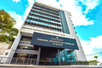 Fachada do TRT de Alagoas com o nome Tribunal Regional do Trabalho da 19ª Região escrito em uma placa de alvenaria de cor preta.