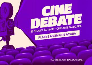 Card de fundo lilás. Há uma máquina de projetando um facho também lilás. No centro da imagem há escrito Cine Debate. Há também na imagem cadeiras de cinema
