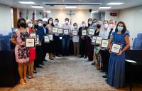 Grupo de pessoas segurando uma placa de premiação