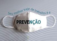 Imagem de uma mácara branca, com a inscrição Seu melhor traje de travalho é aPREVENÇÂO