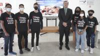 SEis jovem com camisa preta com a frase #chega de trabalho infantil