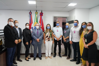 Grupo de seis homens e quatro mulheres em frente as bandeiras de Alagoas e do TRT-19
