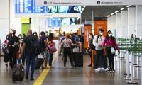 várias pessoas andando no sagão de um aeroporto