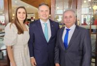 Esposa do ministro Renan Filho, de vestido creme, às esquerda; ministro Renan Filho, de terno azul e gravata verde, ao centro; e desembargador Marcelo Vieira, de terno cinza e gravata azul, à direita. 