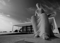 Edificação cinza e preta com escultura simbolizando uma mulher que está com olhos vendados