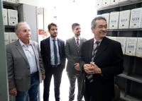 Quatro pessoas de ternos, sendo dois trajando na cor cinza e dois na cor preta
