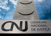 Foto da fachada do CNJ com o a sigla CNJ à esquerda e o nome Conselho Nacional de Justiça à direita.