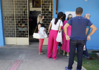 Fila com candidatas e  candidatos para entrar na sala de aplicação de prova