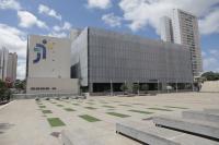 Fachada  do edifício-sede do TRT-18 (GO) na cor cinza claro. Há ainda na fachada a logomarca da Justiça do Trabalho nos tons de azul escuro e amarelo.