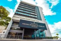Edifício nas cores cinza e preto. ao fundo, o céu com nuvens brancas.
