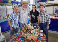 Na foto, quatro pessoas em pé. Na mesa, um balaio com produtos agrícolas.