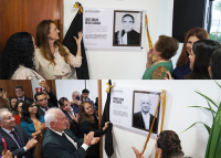 Várias pessoas em frente a duas placas em homenagens a dois homens de ternos escuros.