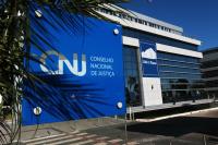 Foto com fachada do CNJ. Prédio tem a cor azul e parede de vidro. 