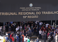 Pessoas reunidas em frente ao prédio sede do Tribunal Regional do Trabalho da 19ª Região