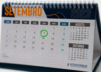Calendário marcando o mês de setembro. Nas cores azul, branco e amarelo. Há um círculo verde em volta do número sete.