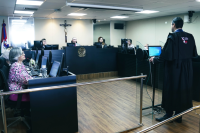 Em pé, homem alta, de costas no púlpito e de toga preta, falando aos desembargadores de TRT.