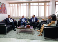 Quatro homens usando terno e uma mulher de vestido bege sentado em sofás conversam. São eles: o ministro Luís Felipe Salomão, os desembargadores Marcelo Vieira, João Leite e Antonio Catão e a assessora do CNJ Monica Drumond