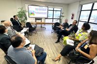 Vários homens e mulheres sentados. Eles estão em uma reunião.