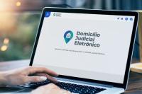 Imagem de notebook com a logo do Domicílio Judicial Eletrônico na tela.