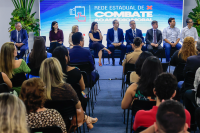 Várias pessoas sentadas. Eles assitem palestras.